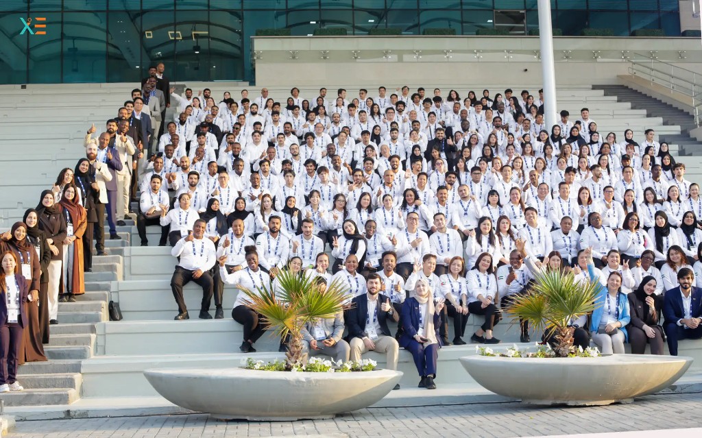 Large Xenial Events team in white uniforms posing on the steps outside ADNEC during ADIPEC 2025
