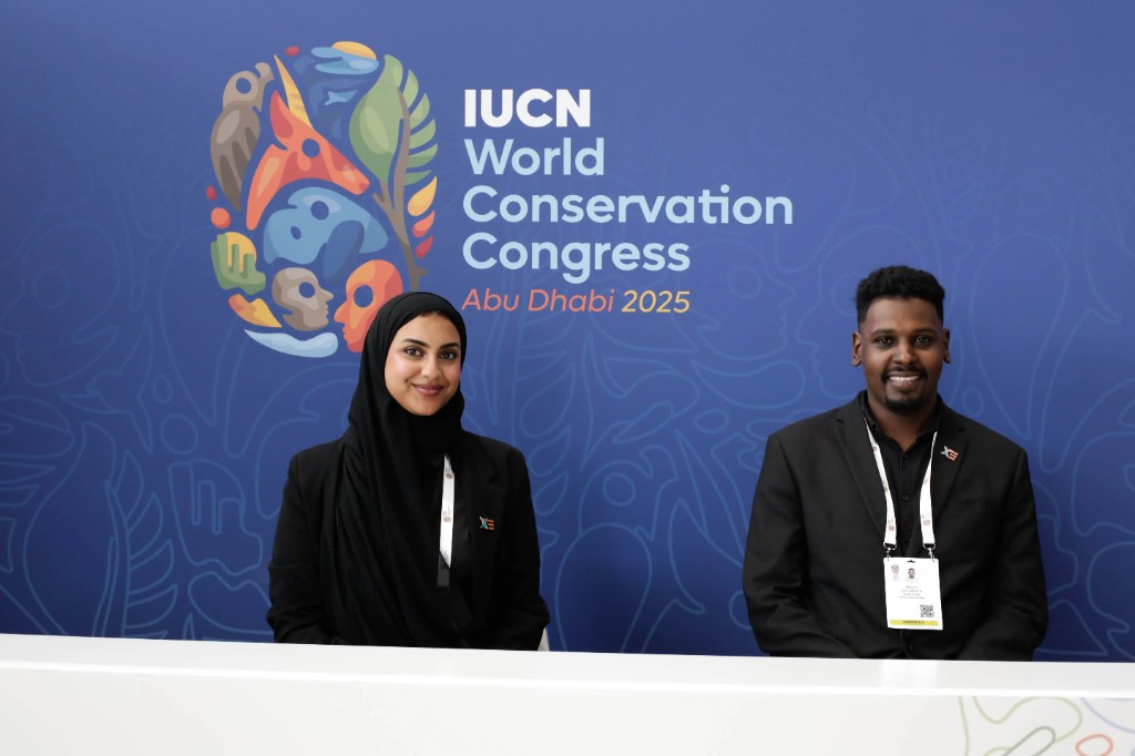 Two collaborators at the IUCN World Conservation Congress welcome desk in Abu Dhabi