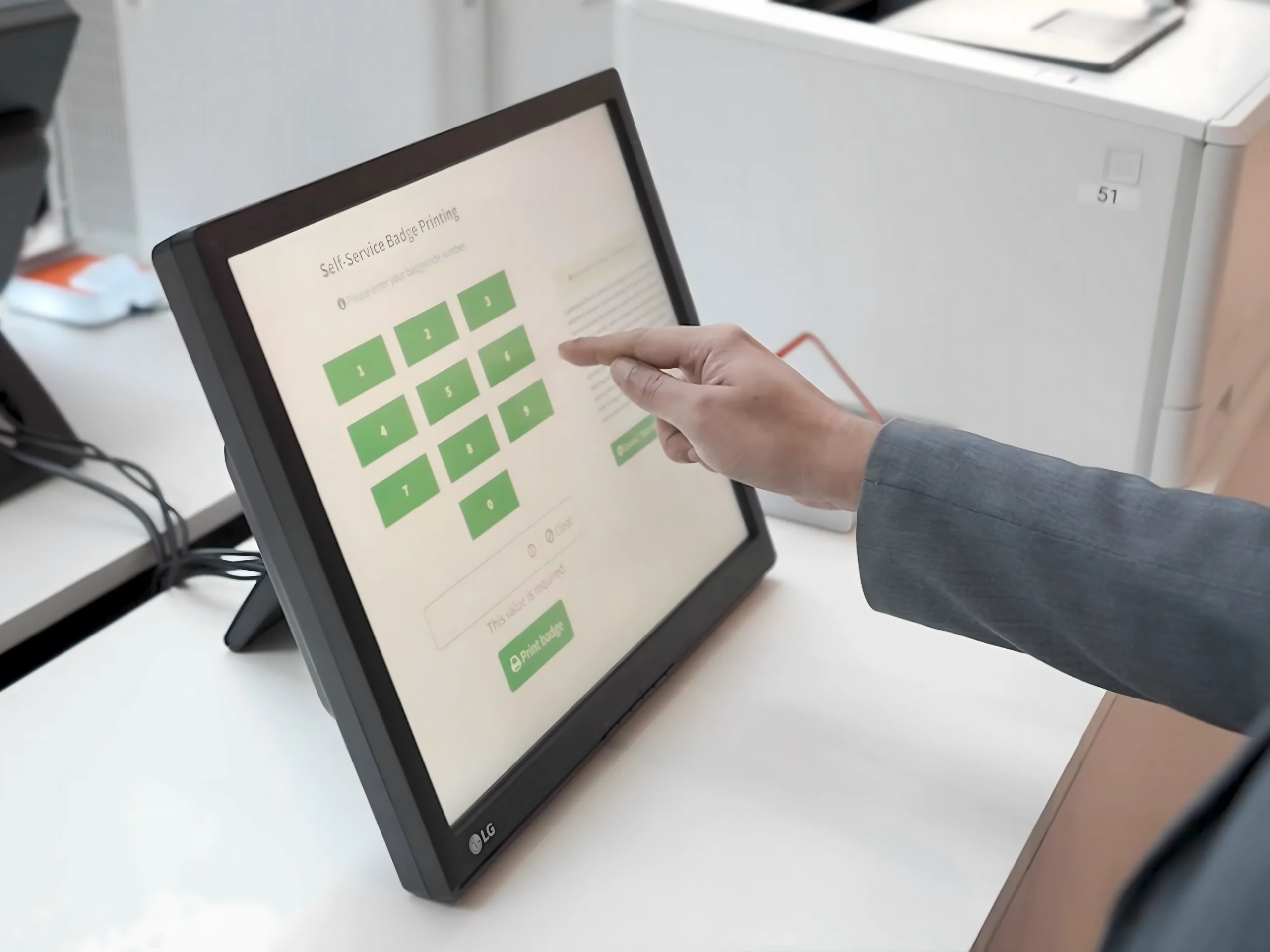 Self-service badge printing touchscreen kiosk at an event registration desk