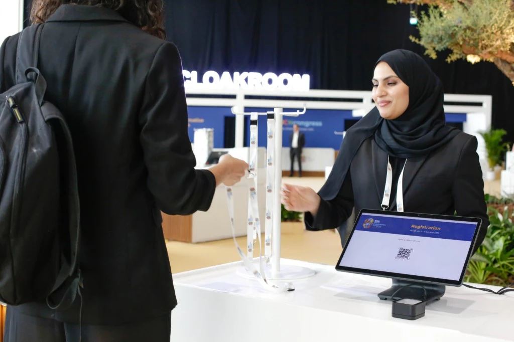 Event registration staff supporting attendees at a Middle East conference