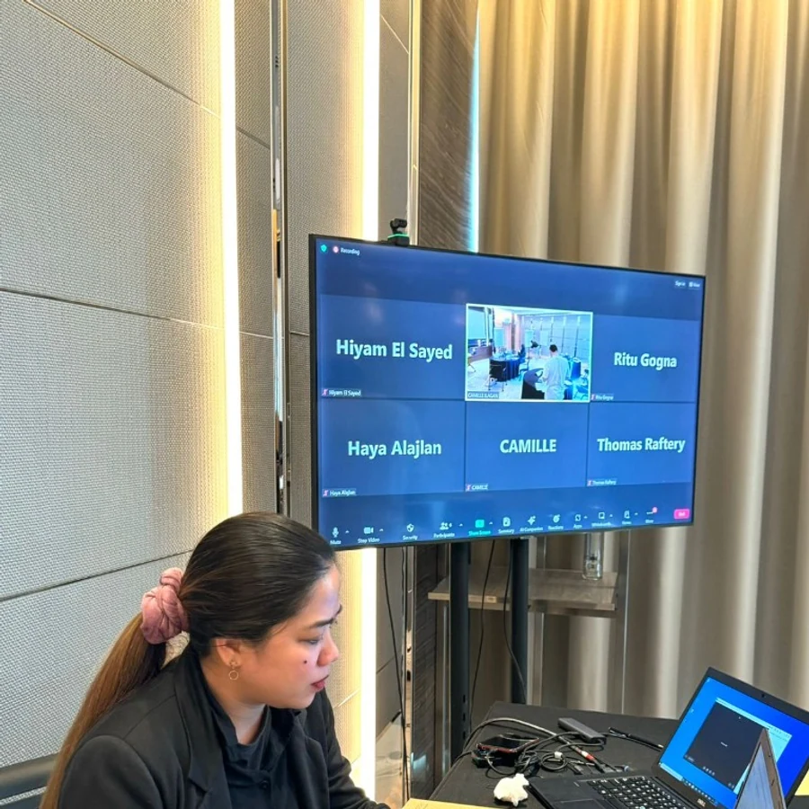 Virtual event moderator managing a live Zoom session from the control desk